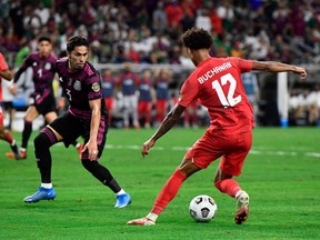 Canada's forward Tajon Buchanan(R) vies for the ball with Mexico's defender Carlos Salcedo (L) during the Concacaf Gold Cup football match semifinal between Mexico and Canada at NRG stadium in Houston, Texas on July 29, 2021.