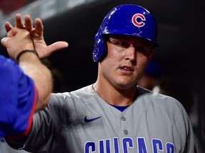 Cubs first baseman Anthony Rizzo is congratulated by teammates after scoring the game-tying run during the ninth inning against the Cardinals at Busch Stadium in St. Louis, July 20, 2021.