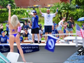 Barclay Goodrow (right) and Brayden Point (left) of the Tampa Bay Lightning celebrate with fans during the 2021 Stanley Cup Victory parade on the Hillsborough River on July 12, 2021 in Tampa, Fla.