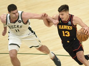 Bogdan Bogdanovic of the Atlanta Hawks drives to the basket against Brook Lopez of the Milwaukee Bucks during the second half in Game 5 of the Eastern Conference Finals at Fiserv Forum on July 1, 2021 in Milwaukee, Wisc.