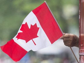 A man waves a flag during a Canada Day parade in Montreal, on July 1, 2018.