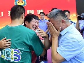 Guo Gangtang, 51, and his wife reunite with their son Guo Xinzhen, who was abducted 24 years ago at the age of 2, at a family reunion arranged by the police, in Liaocheng, Shandong province, China July 11, 2021.