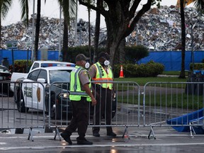 Traffic police officers wear protective masks near the collapsed 12-story Champlain Towers South condo building on July 10, 2021 in Surfside, Florida.