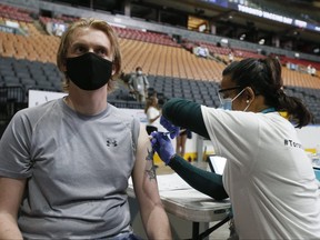 A man gets his COVID-19 vaccine inside Scotiabank Arena in Toronto on the city's Vaccine Day on June 27, 2021.