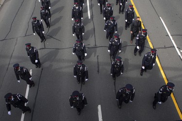 Members of the Toronto Police service form a procession for the funeral of Toronto Police officer Jeffrey Northrup  on Monday  July 12, 2021. Police say that Const. Northrup  was killed in a deliberate act while investigating a robbery  in the parking lot at Toronto City Hall last week.  A 31 year old man has been charged with first degree murder. THE CANADIAN PRESS/Chris Young