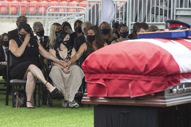 Margaret Northrup (left)  is comforted as she sits alongside her daughter Samantha (centre) at the funeral service for her husband Toronto Police officer Jeffrey Northrup  at his funeral, in Toronto on Monday July 12, 2021.