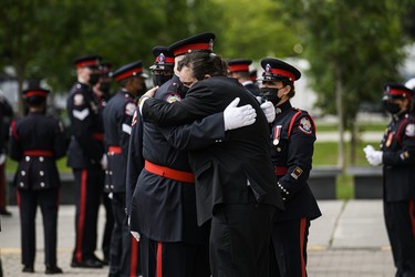Toronto Police Const. Jeffrey Northrup's son Mitchell Northrup (17) is consoled by members of the TPS following his father's funeral service, in Toronto, on Monday, July 12, 2021.