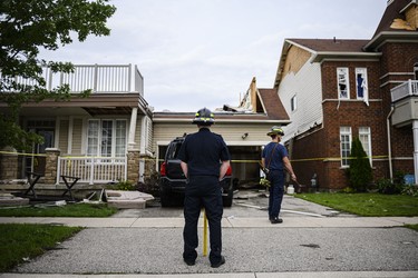 Emergency services examine a home that has had its second floor blown off by a tornado, in Barrie, Ont., on Thursday, July 15, 2021. THE CANADIAN PRESS/Christopher Katsarov
