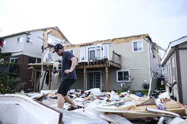 A resident surveys the damage left after a tornado touched down in his neighbourhood, in Barrie, Ont., on Thursday, July 15, 2021. THE CANADIAN PRESS/Christopher Katsarov