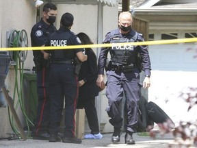 Toronto Police officers are pictured July 14, 2021 at a North York residence following the discovery of a female tenant's body in the basement of the home.