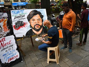 An art teacher gives finishing touches to a painting of Reuters journalist Danish Siddiqui as a tribute outside an art school in Mumbai on July 16, 2021.