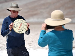 George Harris is photographed by Margaret Owen as he displays a thermometer at Badwater Basin on July 11, 2021 in Death Valley National Park, California.
