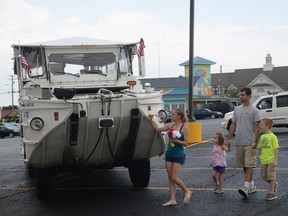 A family of mourners stops to place a flower on a DUKW boat used by Ride The Ducks tours on July 20, 2018 in Branson, Missouri.