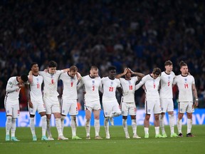 From left to right: Jadon Sancho, Marcus Rashford, Harry Maguire, Harry Kane, Luke Shaw, Bukayo Saka, Raheem Stirling, Jack Grealish, John Stones and Kalvin Phillips look on during the penalty shoot out during the UEFA Euro 2020 Championship Final between Italy and England at Wembley Stadium on July 11, 2021 in London.