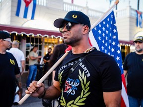 Enrique Tarrio, leader of The Proud Boys, holds a U.S. flag during a protest showing support for Cubans demonstrating against their government, in Miami, Florida on July 16, 2021.