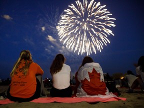 People watch  fireworks fly over Ashbridges Bay during Canada Day festivities, on July 1, 2019 in Toronto.