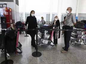 Passengers line up  at Toronto Pearson International Airport on Monday, July 5, 2021.