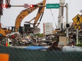 The remaining part of the Champlain Towers South complex is seen behind a street barrier as search-and-rescue efforts resume the day after the managed demolition in Surfside, Fla., Monday, July 5, 2021.
