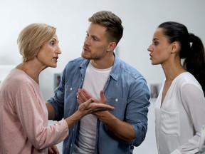 Young man settling conflict between mother and wife, family problems, quarrel