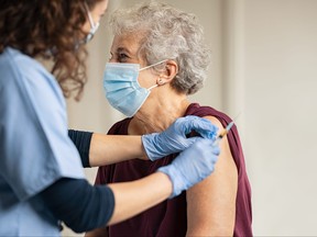 Doctor giving Covid vaccine to senior woman