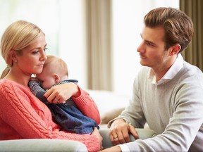 Young couple with baby looking sad