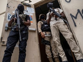 Bodyguards of former senators Steven Benoit and Youri Latortue guard the doorway outside the court house during a hearing following the assassination of President Jovenel Moise, in Port-au-Prince, Haiti July 12, 2021.