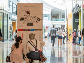 Two shoppers inspect the store directory at Sherway Gardens mall during the stage two reopening COVID-19 restrictions in Toronto June 30, 2021.