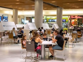 People eat in the food court at the Eaton Centre in Toronto on July 31, 2020.