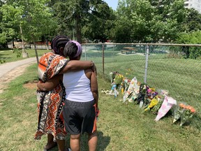 Natalie MacIntosh (left) and Ursular Francis look over a makeshift memorial for Caden Francis, 16, who was gunned down.