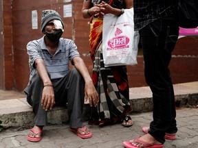 Shivaji Veer, 51, a school bus driver, accompanied by his wife Vimal Veer 46, waits to board a taxi to go home after a follow-up consultation at a hospital after losing his eye due to mucormycosis, also known as black fungus, in Pune, India, July 1, 2021.
