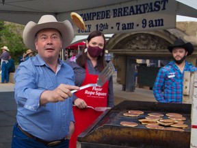 Alberta Premier Jason Kenney keeps a sharp eye on the prize as he shows off his pancake flipping skills at the annual Premier's Stampede Breakfast in downtown Calgary on Monday, July 12, 2021.