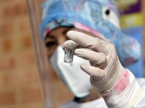 A health worker shows a vial of the Jenssen COVID-19 vaccine from the Johnson & Johnson laboratory at Centro Crecer Balcanes municipal homeless shelter on July 2, 2021, in Bogota, Colombia.