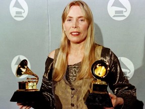 In this file photo taken on Feb. 27, 1996, Joni Mitchell holds two Grammy Awards at 38th Annual Grammy Awards in Los Angeles.