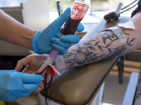 A person donates blood at a Canadian Blood Services donor centre in London, Ont. on Aug. 4 2020.