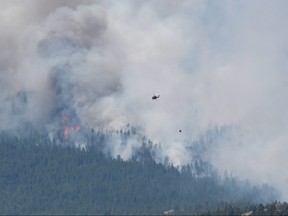 A wildfire burns outside of the town of Lytton, where it raged through and forced everyone to evacuate, in B.C., July 1, 2021.