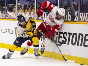 Rocco Grimaldi of the Nashville Predators checks Marc Staal of the Detroit Red Wings as they battle for the puck at Bridgestone Arena on March 23, 2021 in Nashville.