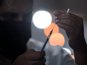 A health worker prepares a dose of Pfizer-BioNTech COVID-19 vaccine, during a mass vaccination, performed at night due high temperature in Mexicali, state of Baja California, Mexico, July 2, 2021.