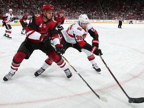 Colin White of the Ottawa Senators attempts to control the puck against Niklas Hjalmarsson of the Arizona Coyotes at Gila River Arena on October 30, 2018 in Glendale, Arizona.