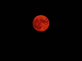 The moon glows burnt orange behind thick wildfire smoke in Blush, Oregon, Friday, July 23, 2021.