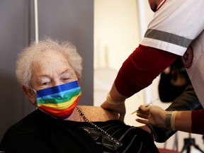 An elderly woman receives a booster shot of her vaccination against COVID-19 at an assisted living facility, in Netanya, Israel, Jan. 19, 2021.