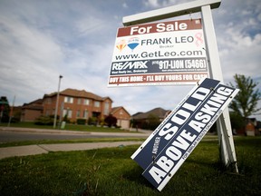 A real estate sign that reads "For Sale" and "Sold Above Asking" stands in front of housing in Vaughan May 24, 2017.