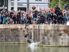 The statue of 17th century slave trader Edward Colston falls into the water after protesters pulled it down and pushed into the docks, during a protest against racial inequality in the aftermath of the death in Minneapolis police custody of George Floyd, in Bristol, Britain, June 7, 2020.
