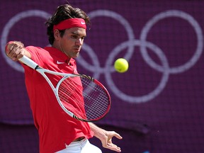 In this file photograph taken on August 5, 2012, Switzerland's Roger Federer returns the ball to Britain's Andy Murray during the London 2012 Olympic Games at Wimbledon in London.