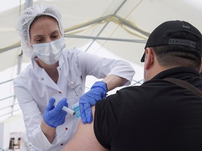 A migrant worker receives a jab while being injected with the one-dose Sputnik Light vaccine against COVID-19 in a vaccination centre at a city market in Moscow, Russia, June 30, 2021.