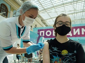 A woman receives a dose of Sputnik V (Gam-COVID-Vac) vaccine against COVID-19 at a vaccination centre in Moscow, Tuesday, July 6, 2021.