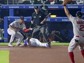 Boston Red Sox third baseman Rafael Devers makes the catch as Blue Jays first baseman Vladimir Guerrero Jr. slides safe during the fourth inning at Sahlen Field on Monday, July 19, 2021.
