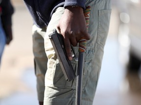 A man holds a pistol as the country deploys the army to quell unrest linked to the jailing of former South African President Jacob Zuma, in Vosloorus, South Africa, July 14, 2021.