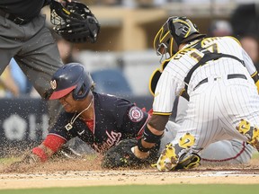 Starlin Castro of the Washington Nationals is tagged out at the plate by Victor Caratini of the San Diego Padres at Petco Park on July 6, 2021 in San Diego.