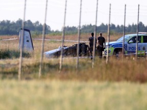 Police officers observe a small aircraft that crashed at Orebro Airport in Orebro, Sweden, Thursday, July 8 2021.