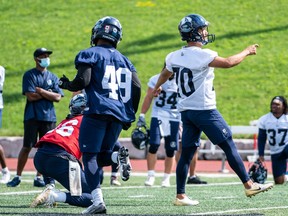 Toshiki Sato right) watches the flight of his kick during Wednesdays Argonauts training camp at the University of Guelph.
